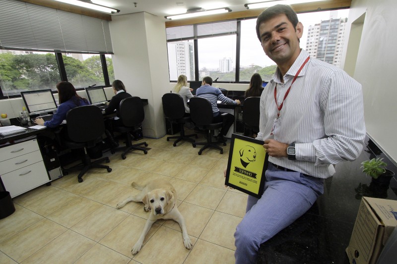 >> Tessmann com o cachorro Topinho, mascote da equipe do escritório