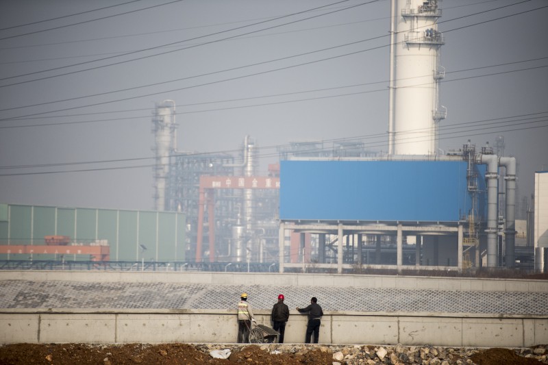  TO GO WITH AFP STORY: Climate-warming-UN-COP21-China-coal  Workers stand in front of a coal-to-oil plant in Changzhi, in Shanxi province, on November 9, 2015.  Obscured by polluted haze, workers are putting the finishing touches to towering smokestacks on a multi-billion-dollar coal-to-oil plant in China that will pump out vast amounts of carbon dioxide when in operation.     AFP PHOTO / FRED DUFOUR  