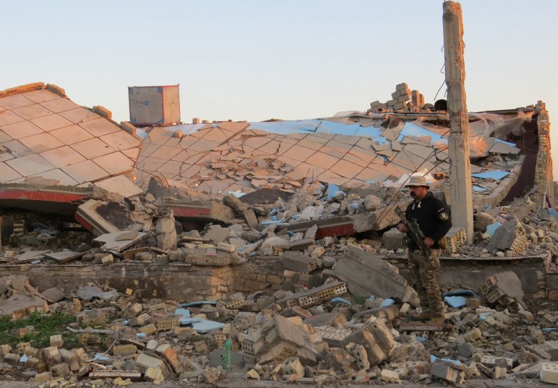  INT - Província de Anbar, capital de Ramadi, no Iraque.    A member of the Iraqi security forces stands in the rubble of destroyed buildings in the rural Husayba al-Sharkiya area, east of Anbar province's capital Ramadi, as they undertake military operations to attack Islamic State (IS) group positions on December 20, 2015. IS took full control of Ramadi in mid-May, in what was Baghdad's most stinging defeat since it launched a counter-offensive to regain the large regions the jihadists captured in the summer of 2014, but Iraq's defence minister predicted on December 19 that security forces backed by US-led coalition air strikes would retake full control of the city of the province's capital by the end of the year. AFP PHOTO / STR  