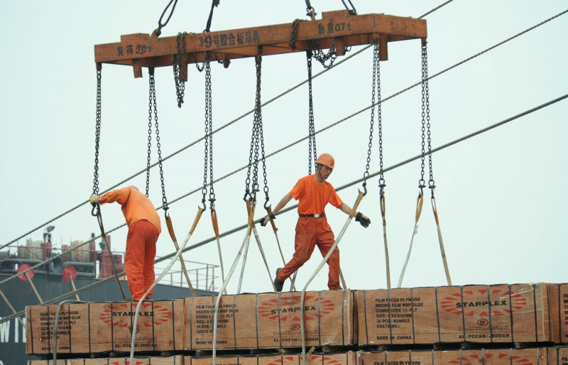  WORKERS LOAD GOODS IN A PORT IN LIANYUNGANG, EAST CHINA'S JIANGSU PROVINCE ON JULY 1, 2014.  CHINESE MANUFACTURING ACTIVITY EXPANDED AT ITS FASTEST PACE THIS YEAR IN JUNE, AN OFFICIAL SURVEY SHOWED JULY 1, IN A SIGN THAT BEIJING'S ATTEMPTS TO TACKLE SLOWING GROWTH IN THE WORLD'S NUMBER TWO ECONOMY ARE GAINING TRACTION.  CHINA OUT     AFP PHOTO  