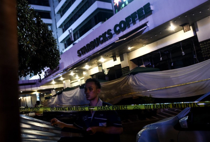  INT - Atentado, Indonésia, EI, Starbucks.    An Indonesian man puts up metal-sheets outside the damaged Starbucks coffee shop after a series of explosions hit central Jakarta on January 14, 2016. A "Paris-style" suicide strike on the Indonesian capital on January 14 confirmed Southeast Asian governments? worst fears -- that citizens returning from fighting alongside the Islamic State group in the Middle East could launch attacks at home.     AFP PHOTO / MANAN VATSYAYANA  