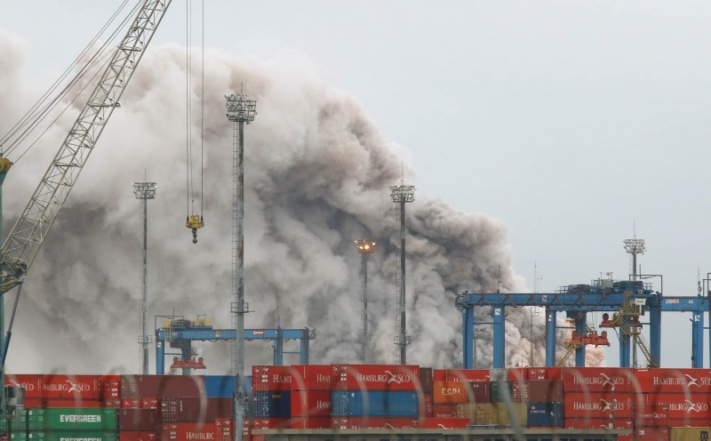  Smoke rises from chemical containers at the port of Guaruja, in the Brazilian coast some 90 km from Sao Paulo, on January 14, 2016. Rainwater got in touch with sodium chloride isocyanate stored in containers causing a chemical reaction, the fire department said.    AFP PHOTO / MAURICIO DE SOUZA  