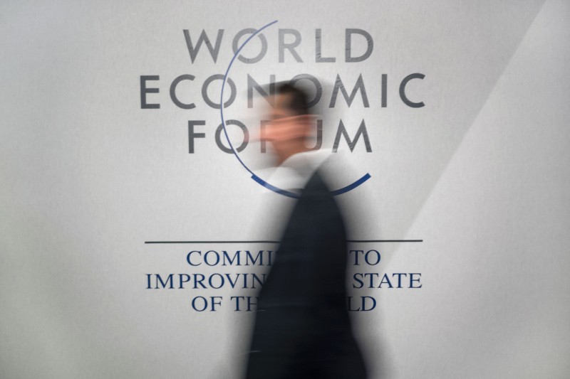 A participant walks past a logo during the World Economic Forum (WEF) annual meeting in Davos, on January 20, 2016.  A string of jihadist attacks and rising risks to the global economy overshadow the opening of the annual gathering of the world's rich and powerful in a snow-blanketed Swiss ski resort. Even as heads of state, billionaires and Hollywood megastar Leonardo DiCaprio were arriving, the International Monetary Fund (IMF) sounded the alarm on January 19, 2016 about perils in the major emerging market economies and lowered its outlook for global economic growth this year. / AFP / FABRICE COFFRINI  