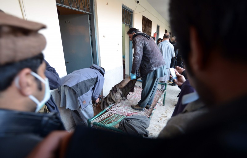  INT - Um atentado a tiros reivindicado por um líder do grupo radical islâmico Taliban contra uma universidade no Paquistão deixou ao menos 20 mortos.      EDITORS NOTE: Graphic content / Pakistani policemen move the body of a Taliban militant at Bacha Khan university following an attack in Charsadda, about 50 kilometres from Peshawar, on January 20, 2016.  At least 21 people died in a Taliban assault on a university in Pakistan, where witnesses reported two large explosions as security forces moved in under dense fog to halt the bloodshed.  / AFP / AAMIR QURESHI  