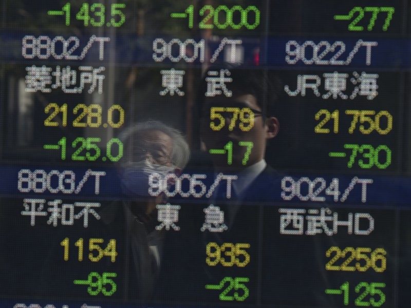  People look at an electric quotation board flashing share prices of the Tokyo Stock Exchange (TSE) in front of a securities company in Tokyo on February 9, 2016. Tokyo shares tumbled nearly five percent, extending a global sell-off as a stronger yen dented exporters and after oil prices tanked again on fears of a deepening economic slowdown.     AFP PHOTO/Toru YAMANAKA  