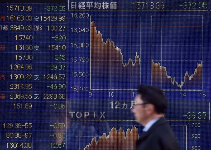  A man walks past an electric quotation board flashing the Nikkei key stock index of the Tokyo Stock Exchange (TSE) in front of a securities company in Tokyo on February 10, 2016. Tokyo stocks again dropped on February 10 to their lowest level since late 2014, as fears of a global recession hammered investor confidence ahead of testimony by the head of the US central bank.      AFP PHOTO / Toru YAMANAKA  