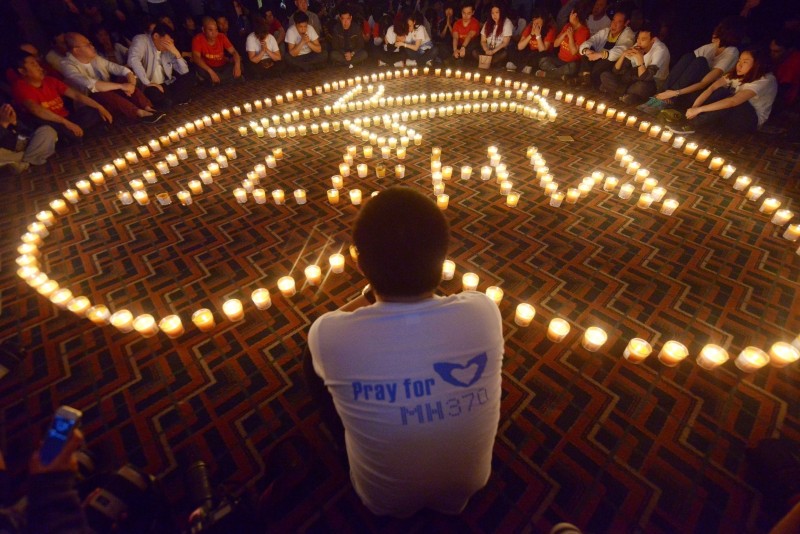  (FILES) This file photo taken on April 08, 2014 shows Chinese relatives of passengers on the missing Malaysia Airlines flight MH370 taking part in a prayer service at the Metro Park Hotel in Beijing.   Malaysia and Australia said they remained "hopeful" of solving the mystery of flight MH370 as the second anniversary of the plane's disappearance arrived on March 8, 2016 with no end in sight for devastated families. / AFP / WANG ZHAO  