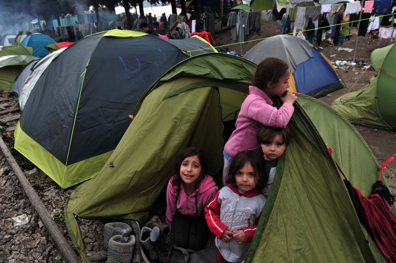  Children stand in a tent on March 10, 2016 at the Greek-Macedonian border near the Greek village of Idomeni where thousands of refugees and migrants are trapped by the Balkan border blockade.  The German and Greek leaders blasted Balkan countries for shutting their borders to migrants ahead of an EU ministers meeting on March 10.   Greek authorities said there were 41,973 asylum seekers in the country, including some 12,000 stuck at Idomeni on the closed Macedonian border. / AFP PHOTO / SAKIS MITROLIDIS  