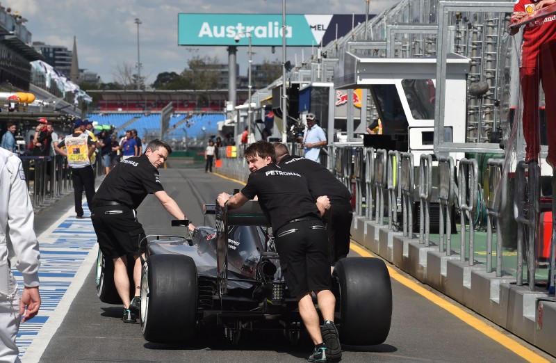  Team members of Mercedes AMG Petronas British driver Lewis Hamilton push his car down pit lane for scrutineering ahead of the Formula One Australian Grand Prix in Melbourne on March 17, 2016.  / AFP PHOTO / Paul Crock / IMAGE RESTRICTED TO EDITORIAL USE - STRICTLY NO COMMERCIAL USE  