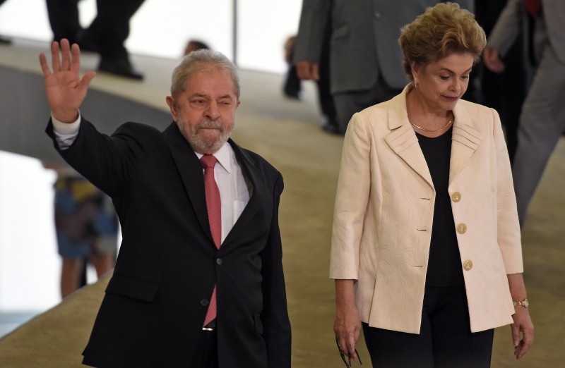  Former Brazilian president Luiz Inácio Lula da Silva (L) and Brazilian president Dilma Rousseff gesture during Lula's swear in ceremony as chief of staff, in Brasilia on March 17, 2016. Rousseff appointed Luiz Inacio Lula da Silva as her chief of staff hoping that his political prowess can save her administration. The president is battling an impeachment attempt, a deep recession, and the fallout of an explosive corruption scandal at state oil giant Petrobras.       AFP PHOTO/EVARISTO SA  