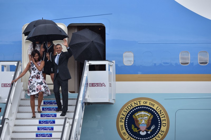  US President Barack Obama (R), First Lady Michelle Obama and daughters Sasha and Malia (behind) arrive at Jose Marti international airport in Havana on March 20, 2016. Obama, who is on a historic three-day visit to the communist-ruled island, flew to Cuba Sunday to bury the hatchet in a more than half-century-long Cold War standoff, but the arrest of dozens of dissidents just as his plane took off underlined the delicacy of the mission. AFP PHOTO/ Yuri CORTEZ  