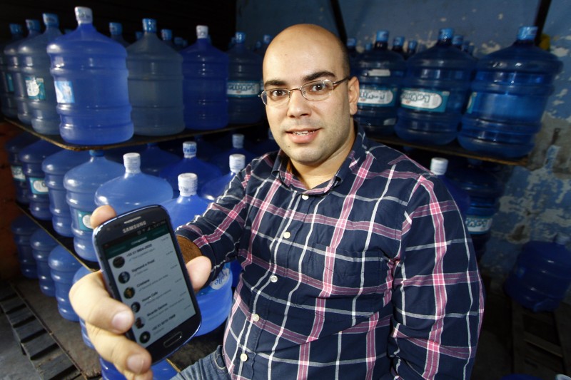 Por dia, Vinicius Teixeira recebe cerca de 30 pedidos de água mineral pelo aplicativo de mensagens Foto: MARCELO G. RIBEIRO/JC
