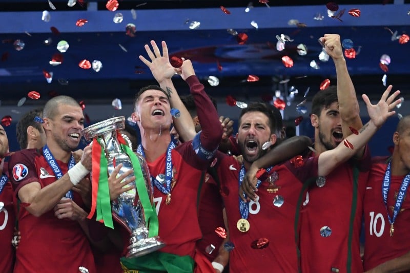 Portugal's forward Cristiano Ronaldo (2ndL) lifts the trophy as he celebrates with teammates (fromL) Portugal's defender Pepe, Portugal's midfielder Joao Moutinho, Portugal's midfielder Andre Gomes and Portugal's midfielder Joao Mario, winning the Euro 2016 final football match between Portugal and France