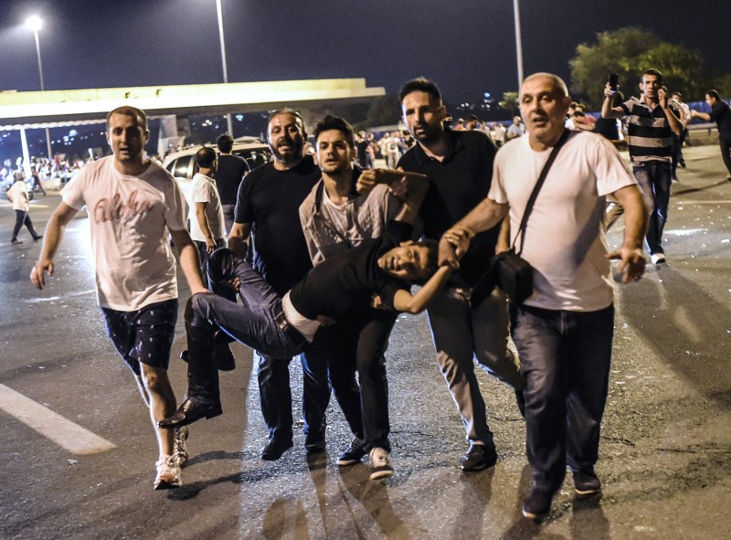 Homem é carregado após levar tiro durante confronto em Istanbul entre a população e as forças armadas