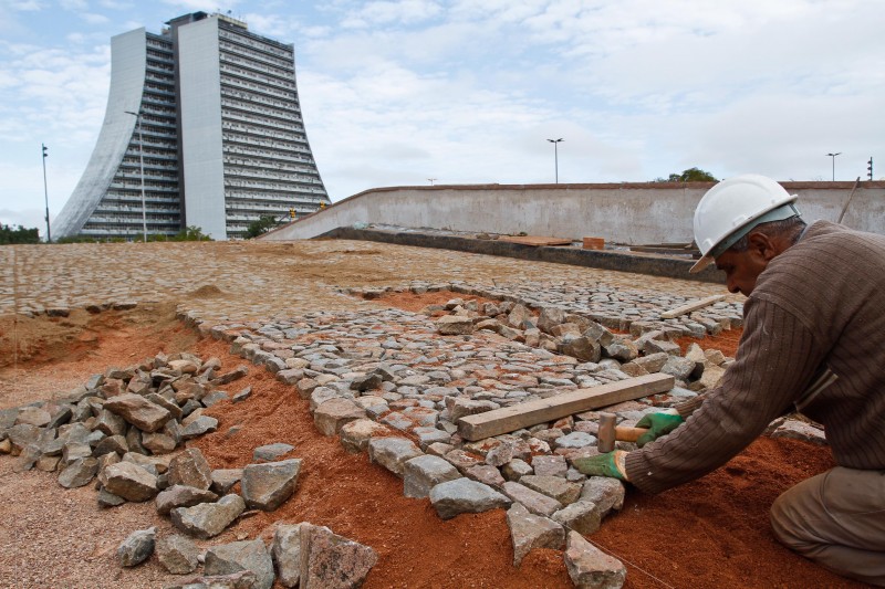Operários trabalham na recolocação do pavimento da Ponte de Pedra no Largo dos Açorianos