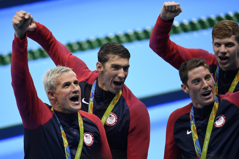 Ryan Lochte (primeiro, à esquerda), alvo da medida, comemora ouro nos 4x200m livre ao lado de Phelps