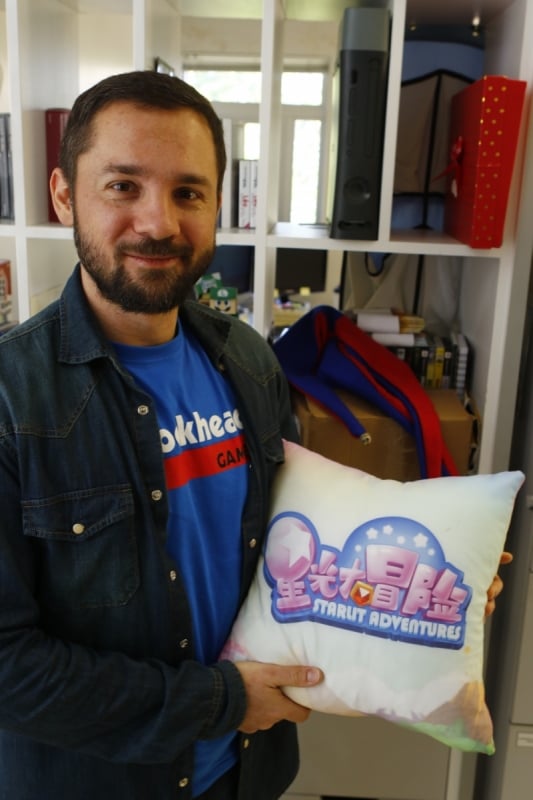 Christian com segura a almofada da vers&atilde;o chinesa do game que criou Foto: FREDY VIEIRA/JC