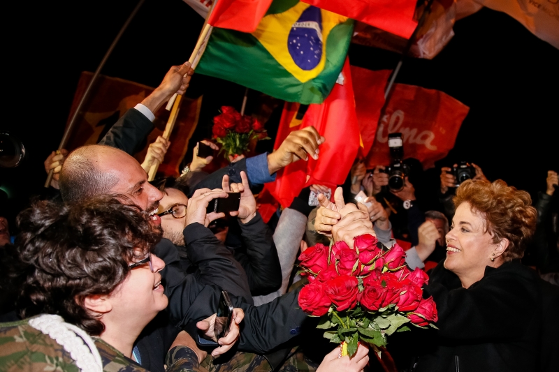 Ex-presidente Dilma é saudada por apoiadores na chegada ao Estado