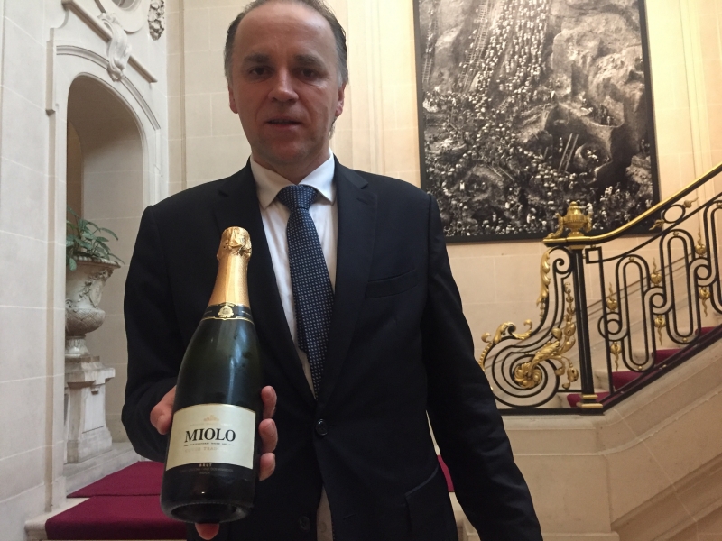 Oliveira mostra a garrafa da espumante brut da Miolo que domina carta de vinhos da embaixada em Paris