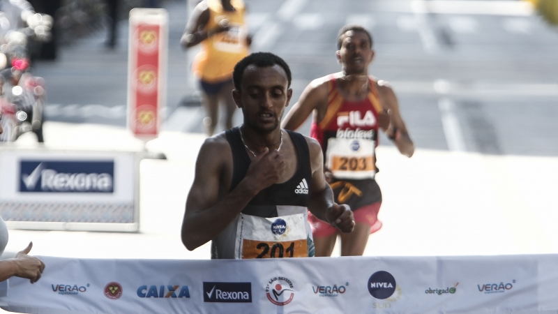 Ethiopian runner Leul Gebresilase Aleme crosses the finish line to win the 92nd Sao Silvestre international 15 km race in Sao Paulo, Brazil, on 31 December 2016. 
Thirty thousand runners participated in the 15 km traditional New Year's Eve event. / AFP PHOTO / Miguel SCHINCARIOL