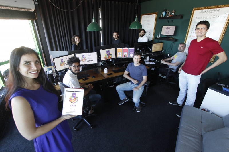 Juliana (esq.) e Pedro (dir.), CEOs do aplicativo Joyz com a equipe da Aioria, desenvolvedora t&eacute;cnica Foto: MARCELO G. RIBEIRO/JC