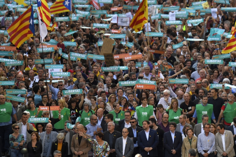 Carles Puigdemont, Oriol Junqueras e manifestantes em demonstração contra o anúncio do governo espanhol nas ruas de Barcelona