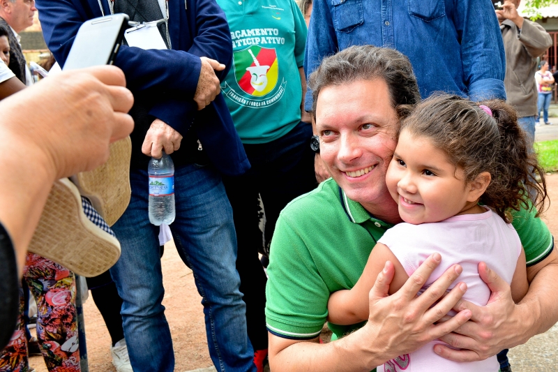 Marchezan Júnior abraça criança em ação no bairro Humaitá
