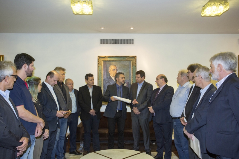 Edegar Pretto (centro) recebeu documento de governo e setor lácteo