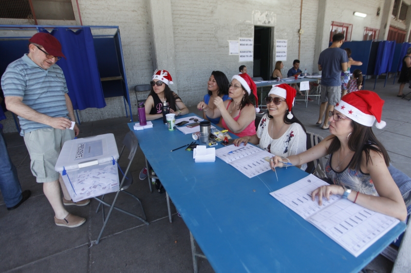 Mesários receberam os eleitores chilenos estilizados com boné de Papai Noel em clima de Natal