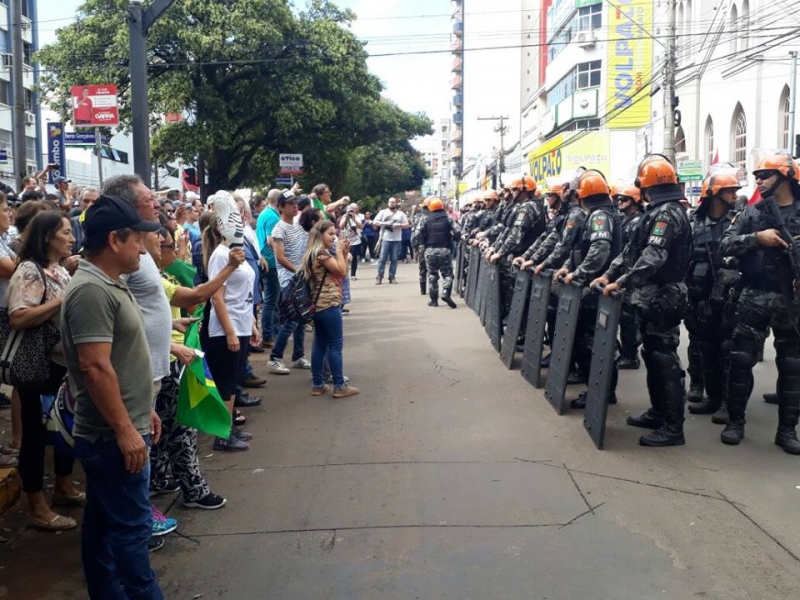 À espera de Lula, manifestantes carregam ovos, chicotes, correntes e até um taco