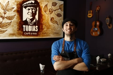 Juliano, em frente ao quadro feito de p� de caf� que faz sucesso no Tobias