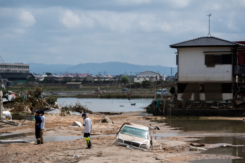 Moradores inspecionam suas casas danificadas em uma área afetada pela inundação em Mabi