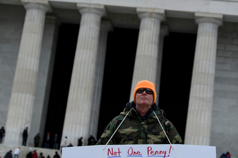 Homem segura cartaz em protesto em frente ao monumento de Lincoln em Washington