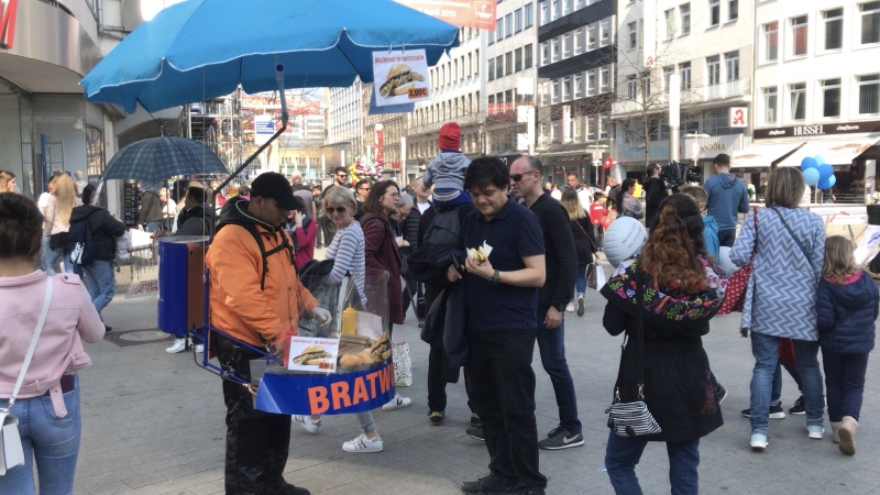 Homem leva no corpo os artefatos para vender o lanche nas ruas de Hannover