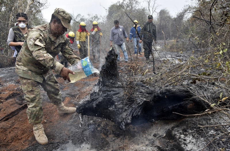 População e Exército boliviano tentam apagar fogo com uso de baldes em regiões atingidas