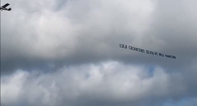 Aeronave voou com faixa com frase dizendo "Lula cachaceiro devolve meu dinheiro"