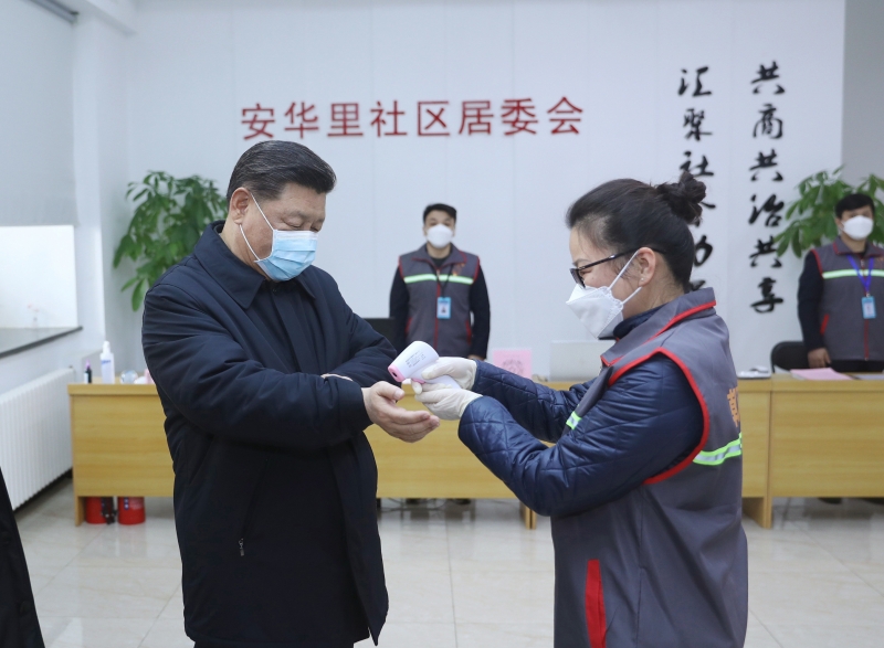 Xi Jinping usa máscara e uma funcionária da saúde checa a temperatura em ação de prevenção
