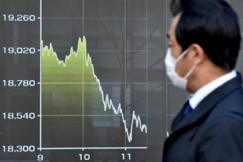 Pedestre observa queda da Nikkei, principal índice da bolsa de valores de Tóquio