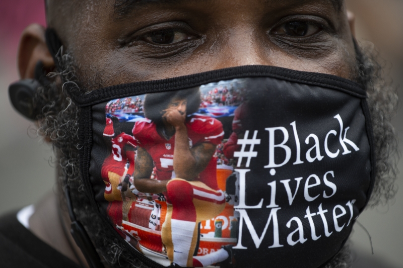 Gesto de Colin Kaepernick, estampado na máscara de manifestante, inspira protestos em 2020