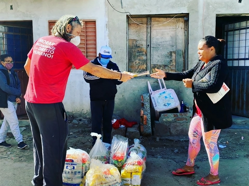 Equipes de voluntários distribuem, além de insumos e cestas básicas, jornais para informar as comunidades