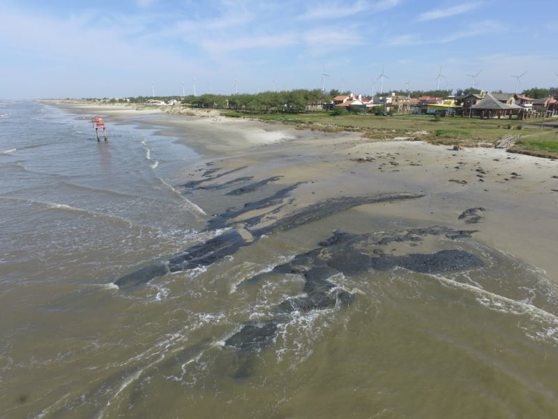 Praia ficou marcada pelo rastro da lama preta que foi descoberta pelas ondas nas ressacas