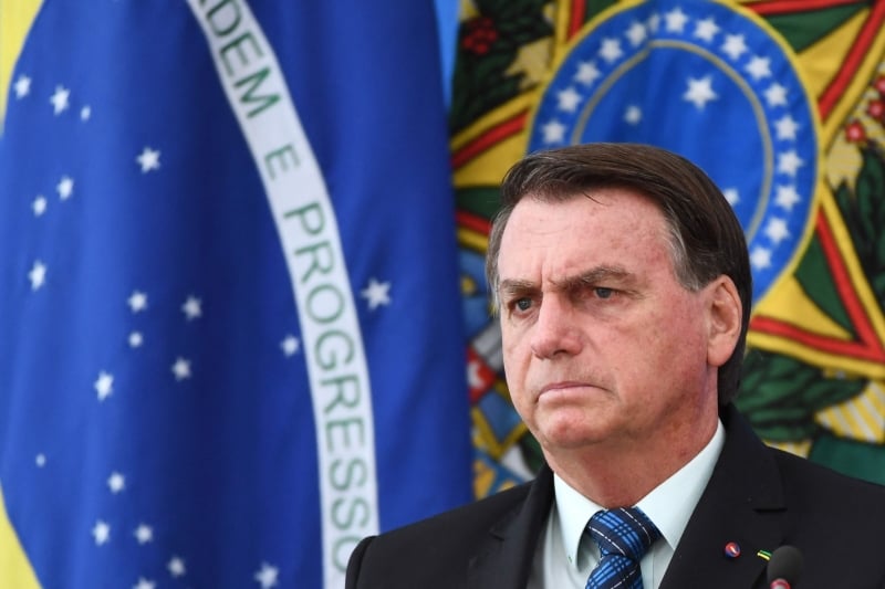 (FILES) In this file photo taken on February 5, 2021 Brazilian President Jair Bolsonaro gestures as he speaks during a press conference on a new fuel tax policy at Planalto Palace in Brasilia. - Brazil's economy shrank 4.1 percent in 2020, officials said on March 3, 2021, closing out what analysts called another 