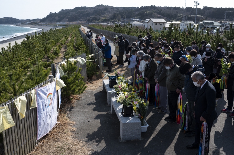Carregando buquês de flores, muitos cidadãos caminharam até a beira-mar para orar por parentes e amigos levados pela água