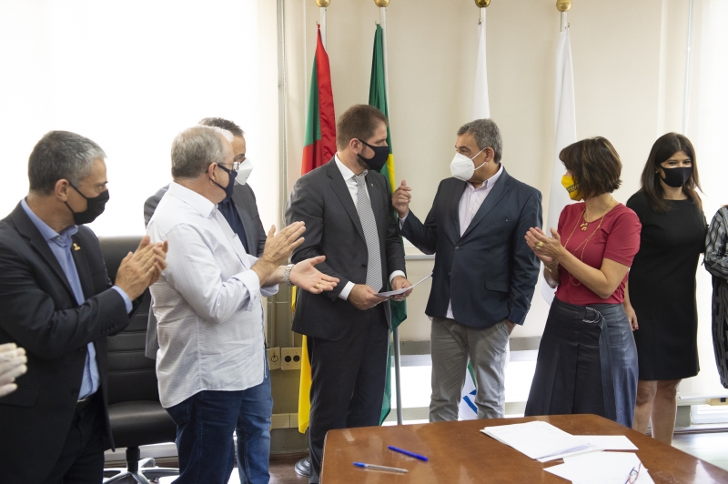 Prefeito Sebastião Melo (d), presidente Marcio Bins Ely, secretários, vereadores e servidores celebram termo de colaboração
