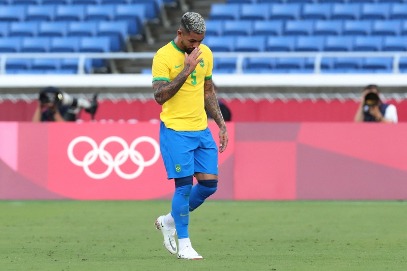 Brazil's midfielder Douglas Luiz walks off the pitch after receiving a red card during the Tokyo 2020 Olympic Games men's group D first round football match between Brazil and Ivory Coast at the Yokohama International Stadium in Yokohama on July 25, 2021. (Photo by Yoshikazu TSUNO / AFP)