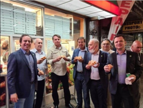 As imagens do presidente e seus auxiliares comendo pizza na calçada foram publicadas pelo ministro do Turismo, Gilson Machado, nas redes sociais
