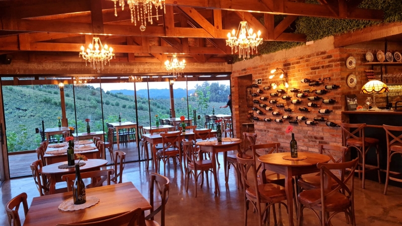 Casa conta com 23 mesas no salão principal, além de área externa com deque e jardim, em meio aos parreirais