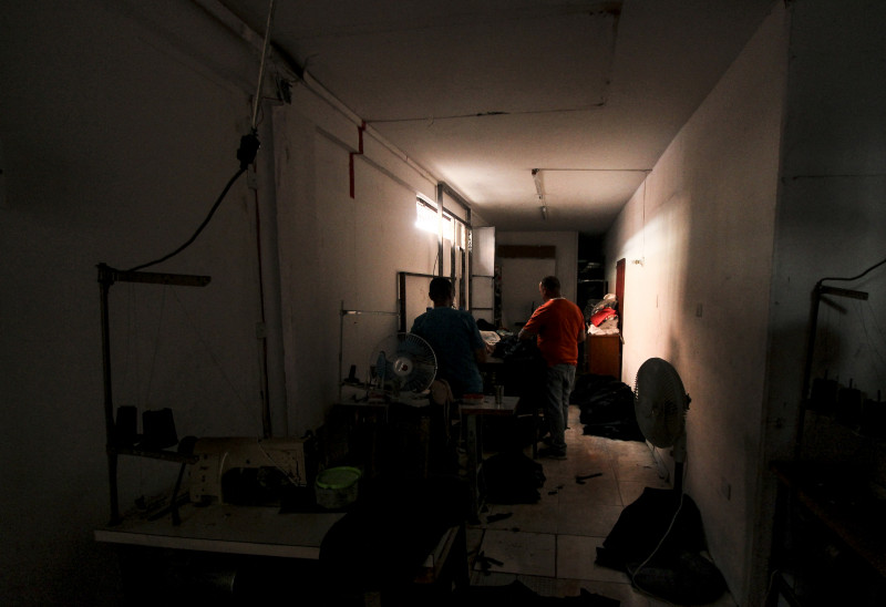 Em Ureña, operários fazem trabalhos manuais às escuras, em meio a máquinas desligadas