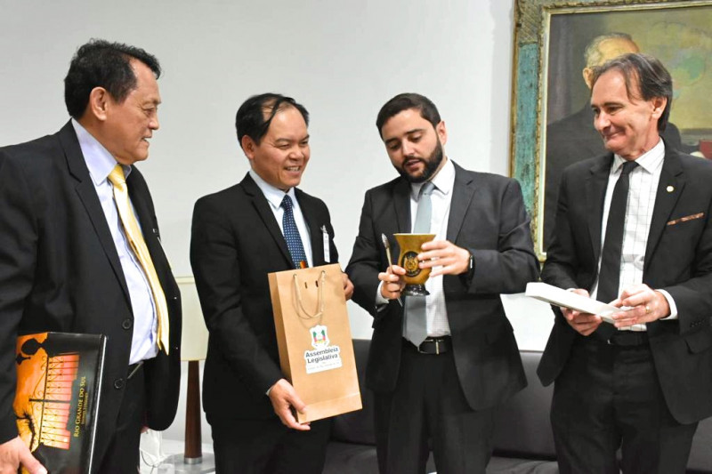 Souza (centro, à direita) deu uma cuia e bomba a Ty e explicou como é o preparo do chimarrão