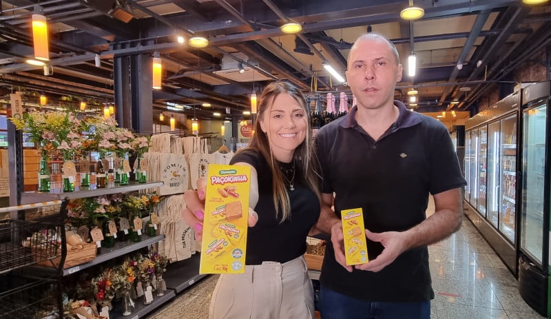 Mariana e Winckler mostram paçoca com o sistema de leitura vendidas no Espaço Brasco